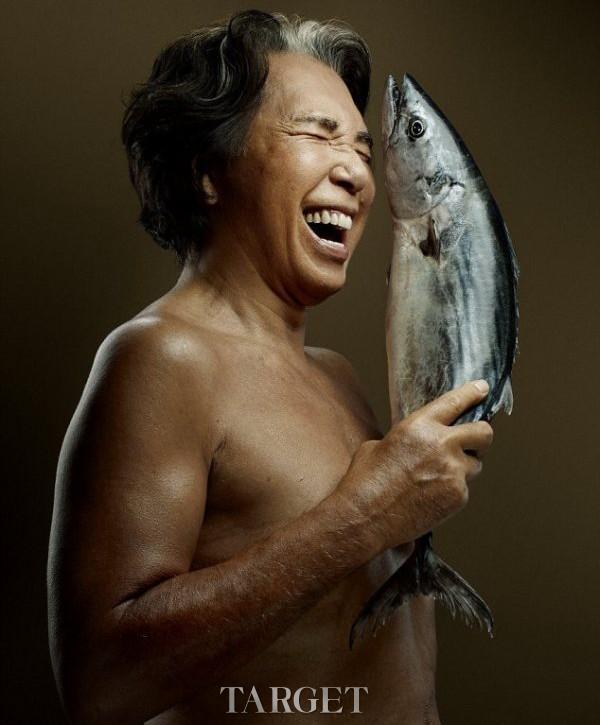 日本时尚设计师Kenzo拿着一条鲣鱼做出大笑的表情